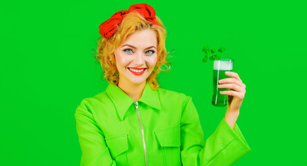 Happy girl with green beer. Patrick's Day. Smiling woman drinking Green beverage with clover.
