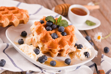 Waffles with blueberries and whipped cream.
