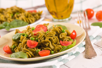 Fusilli pasta with cherry tomatoes and peas.