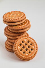 Sweet sandwich cookies close up with chocolate filling on a white background.