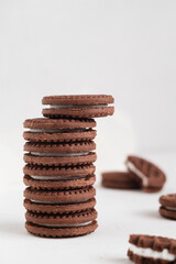 Stack of chocolate sandwich cookies close up. Cookies with cream filling. Sweet food concept.