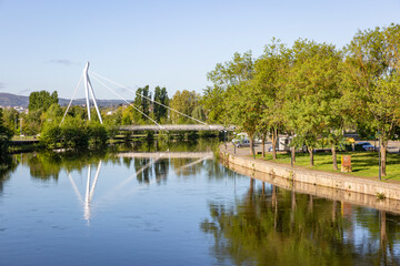 Fototapeta na wymiar Pedestrian Bridge over Tamega River and Tabolado Garden at Chaves city, district of Vila Real, Portugal