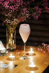 beautiful pink cocktail with colored sprinkling in the night bar