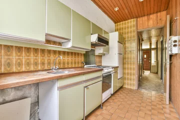Fotobehang old fashioned kitchen with green cabinets and a white fridge © Casa imágenes