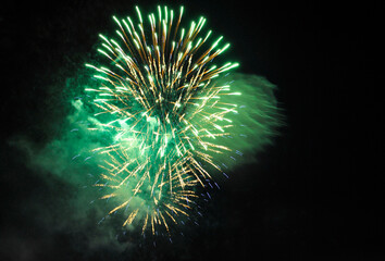 Colorful salute, great explodes in different colors in the night sky, beautifully dissolving in the air.