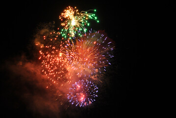Colorful salute, great explodes in different colors in the night sky, beautifully dissolving in the air.