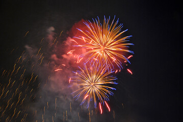 Colorful salute, great explodes in different colors in the night sky, beautifully dissolving in the air.