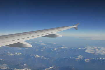 Airplane's wing during a flight over the Alps
