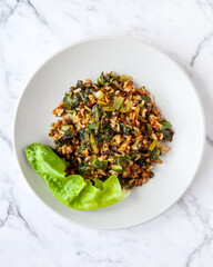 Rice fried with lettuce leaves. Top view meal plate on marble table.