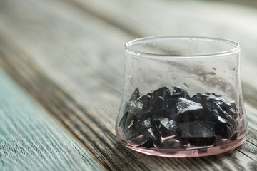 Russian shungite stones on a wooden  background used in alternative medicine for water purification 