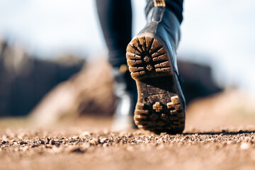 Detail of a young woman's boots walking through the field