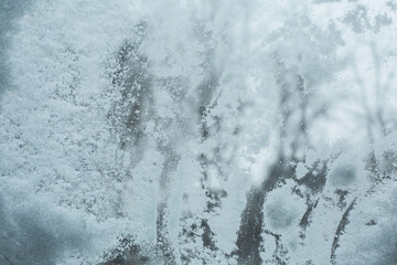 Frost on the vehicle glass. Weather. Winter blizzard. Car window cleaning. White snow. 