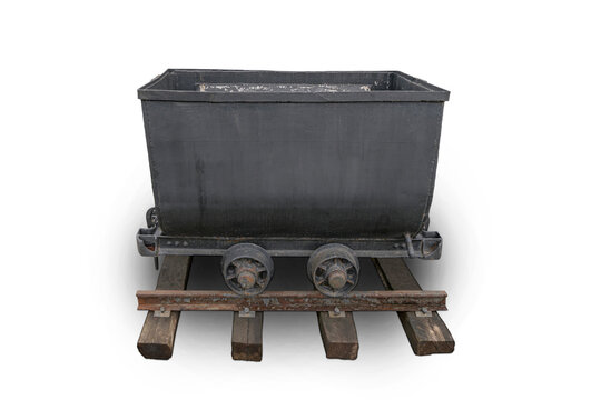 Old iron mine trolleys for coal on rusty rails isolated on white background