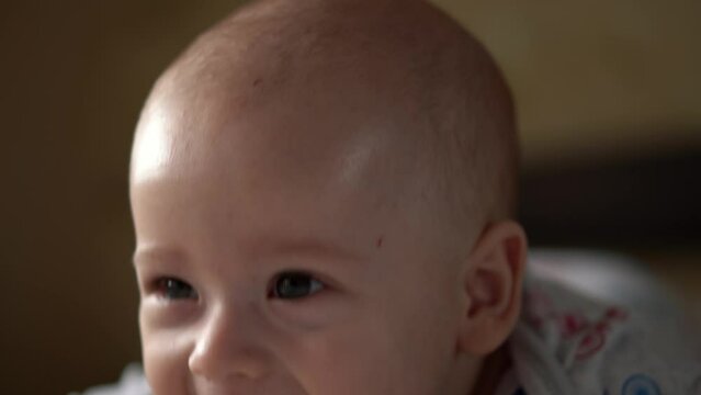 Newborn Active Baby Cute Smiling Teethless Face Portrait Early Days On Stomach Developing Neck Control. 5 Months Child On White Bed Looking on Camera. Infant, Childbirth, Parenthood, Beginning Concept