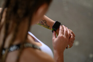 Woman in sportswear checks fitness and health tracking on her smartwatch after training