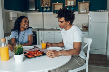 African american couple having breakfast in the kitchen at home
