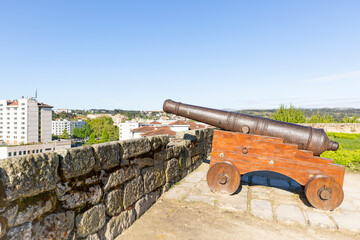 Fototapeta na wymiar an antique cannon on a wooden chariot inside the castle wall with a view over Chaves city, district of Vila Real, Portugal
