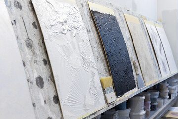 
Working brush against the background of decorative plasters indoors