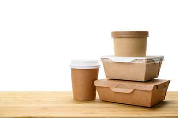 Several paper containers for food delivery on a wooden table. Isolated white background. Template for advertising food delivery.