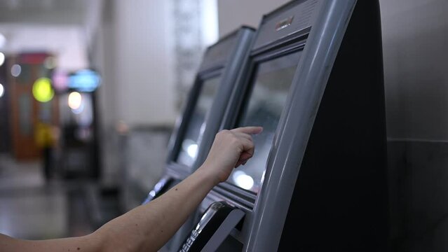 A woman uses a self-service checkout. Close-up of the hands of an online cash register user.