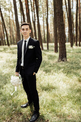 handsome and funny groom posing in nature. groom's portrait. wedding day concept.