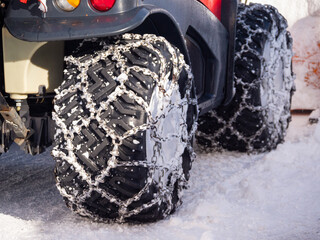 Wheels with snow chains on the vehicle for clearing snowy roads - snow plow.