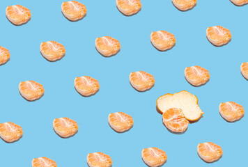 Fruit pattern of fresh tangerine slices on pastel blue background. Summer creative concept. From top view.