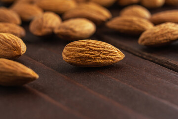 Macro of almonds on dark wooden table. Organic health protein vegetarian food. Background copy space
