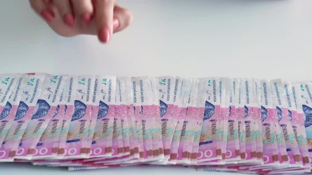 Money savings. Ukrainian hryvnia. UAH foreign currency. Rich female hand counting 200 hrn bill banknotes cash pile isolated on white copy space background.