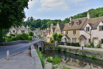 Fototapeta na wymiar Scenic view of traditional old cottage houses by a river in a beautiful English village - namely the landmark village of Castle Combe in Wiltshire England