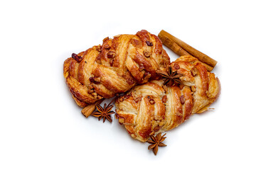 Isolated home-made out-of-oven Danish pastry with maple syrup decorated with cinnamon sticks and star anise