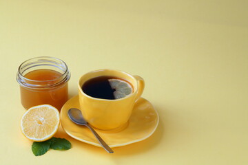 tea cup, lemon, honey - all yellow on a yellow background