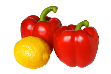 Two red peppers with green stalks and a lemon