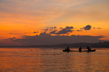 sunset with dolphin in silhouette on the amazon river in Puerto Nariño, Colombia