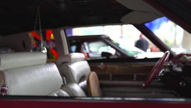 This panning side view video shows the custom interior of a 1970's Cadillac lowrider car with playboy windows.
