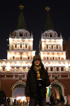 Happy smiling young men portrait in Red Square, Moscow. A student in the city is holding a coffee.