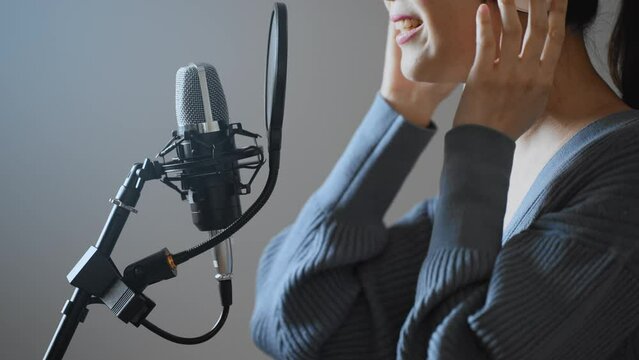 歌の収録をする若い女性
