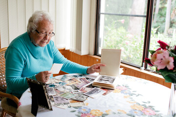 Elderly lady browsing through photographs