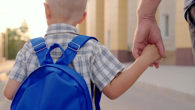 Schoolboy with school backpack goes to school with his dad. Happy family. Education for children. Happy son, boy with school backpack hurries to school. Family, Kid, Boy, dad go home from school
