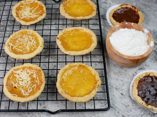 Pineapple, cheese and chocolate flavored pies on a cooling rack. bakery food concept
