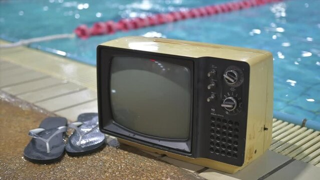 old television set and flip flops on the side of the swimming pool for slideshow template