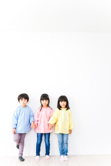 Fototapeta na wymiar 壁に並ぶ3人の幼稚園児