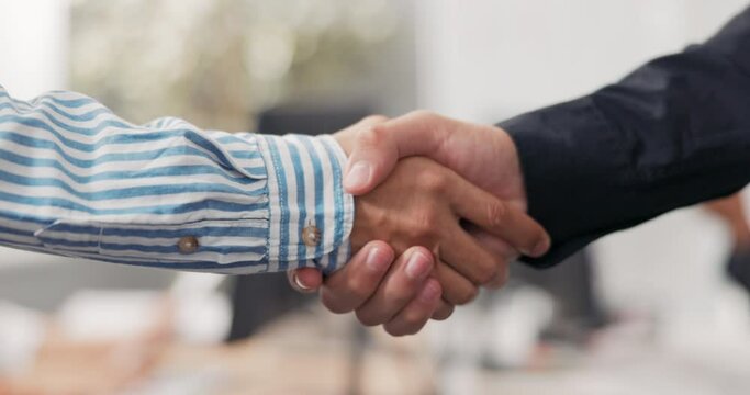 Close-up of two male hands in the middle of a corporate office in the background, they are shaking hands firmly, greeting, saying goodbye, getting acquainted, congratulating, pride, joy