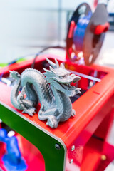 3D printer printing dragon figure close-up.