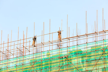 construction workers build scaffolding at a construction site in North China
