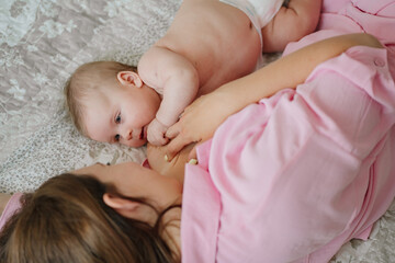 mom lie in bed with baby. the happiness of motherhood. breastfeeding.