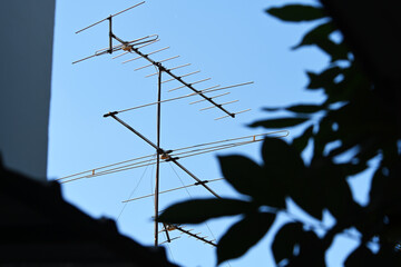 photo of television antenna on blue sky background