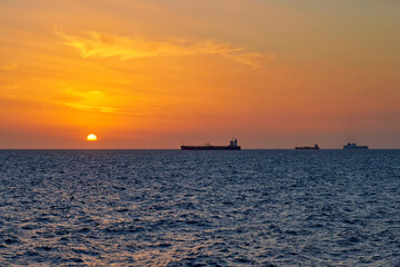 Sea view at sunset with ships moored in the roadstead. Italy, Liguria