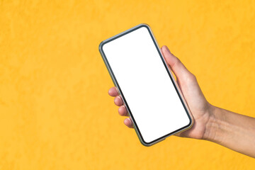 Close-up, Mockup of a smartphone in a girl's hand. Against the background of a yellow facade made of decorative plaster.
