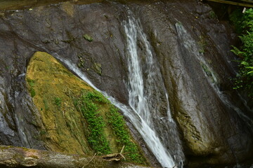 Obraz premium a beautiful waterfall flows over gray stones in the mountains